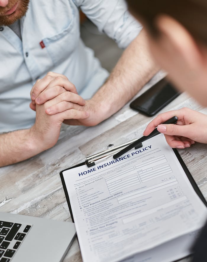 home-img Two adults reviewing a home insurance policy document on a table with electronic devices.