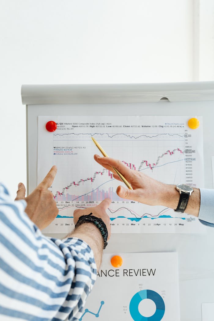 about-img-01 Two people analyzing financial charts on a whiteboard during a business meeting.